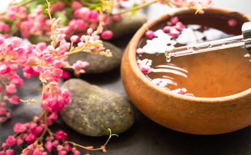 Depositphotos_34001587_S_0018_hand-pour-coconut-oil-aroma-essential-smell-rose-flowers-with-zen-pebblesmassage-oilaroma-